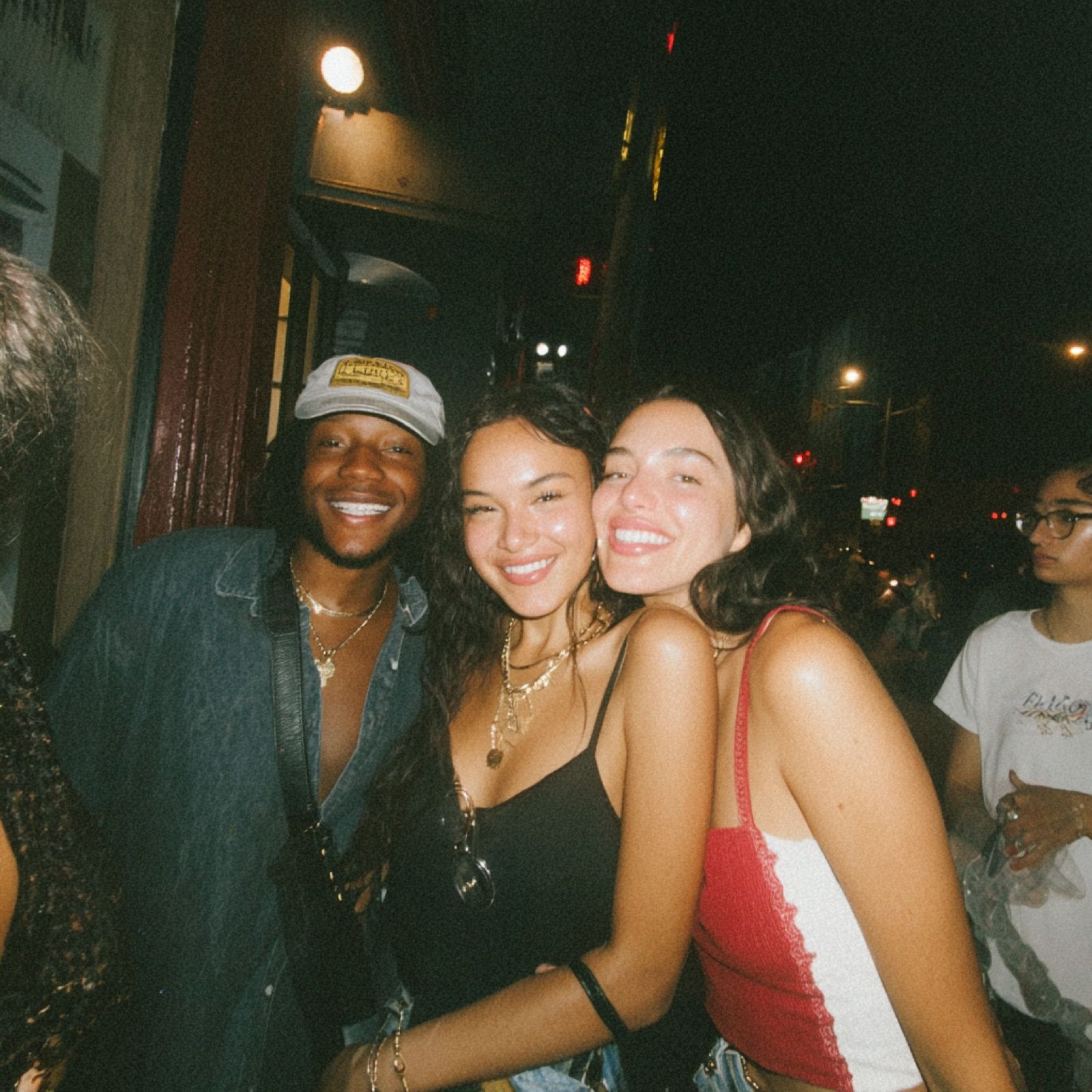 Three friends pressed together, mid-laugh, NYC.